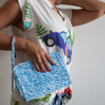 Pochette borsa spesa fatta a mano in Rafia Adriafil sfumata azzurra, indossata da una modella